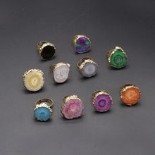 Collection of colorful rings with gold bands on a gray background