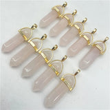 Set of rose quartz crystal pendants with gold accents on a white background