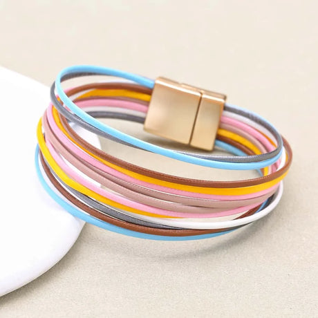 Multicolored bracelet with a gold magnetic clasp on a beige background