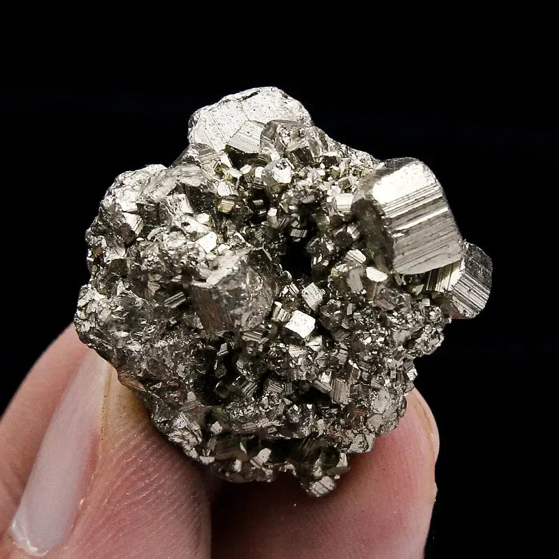 Mineral specimen held in hand against a black background