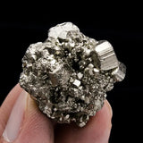 Mineral specimen held in hand against a black background