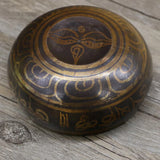 Decorative wooden bowl with intricate carvings on a wooden surface