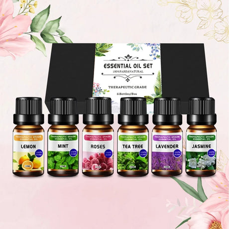Set of essential oil bottles with labels on a pink floral background