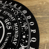 Black and white astrological wheel on a wooden surface