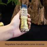 Hand holding Nepalese handmade cone incense with a natural background