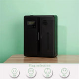 Black electronic device with digital display on a wooden surface against a green background