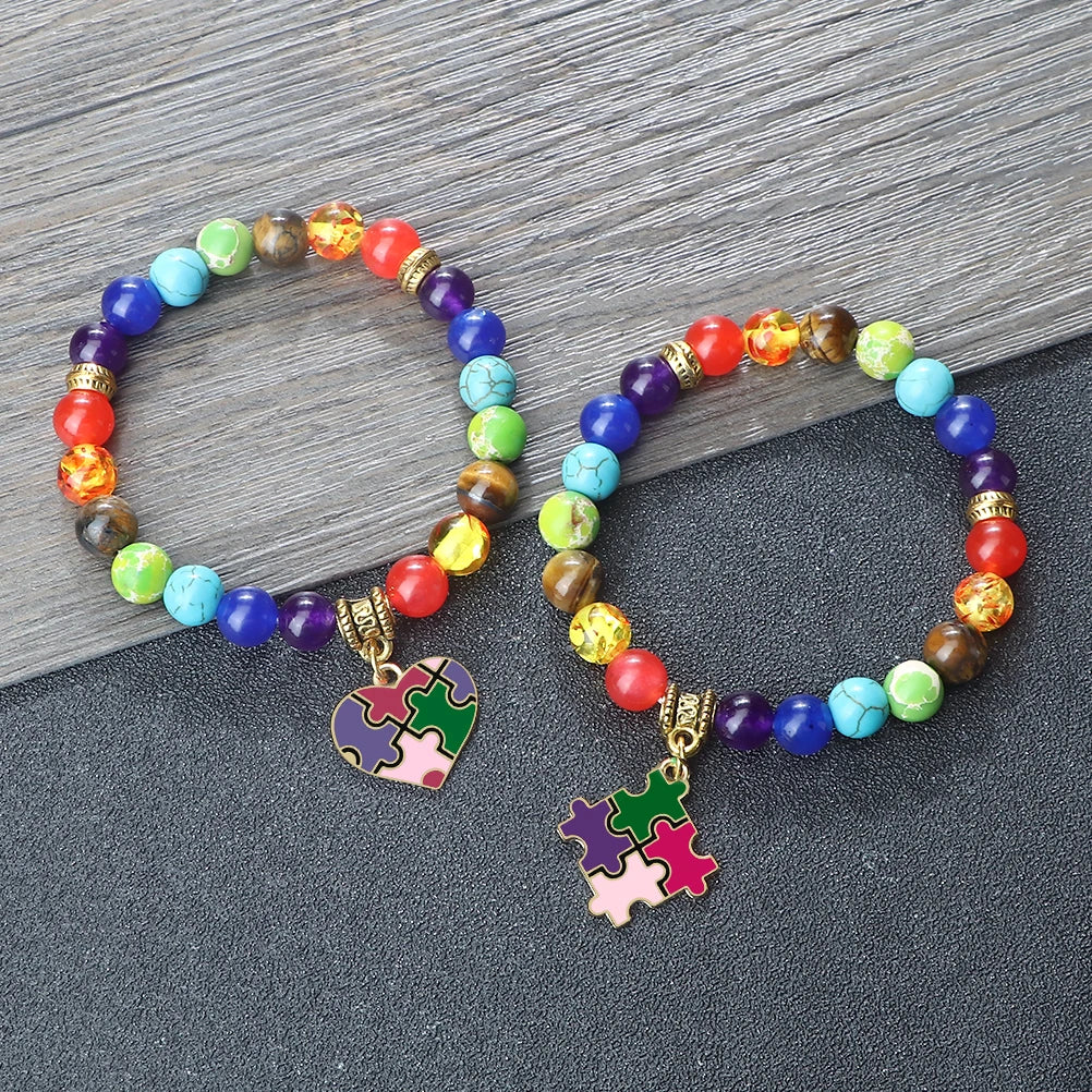 Colorful beaded bracelets with puzzle piece charms on a wooden surface