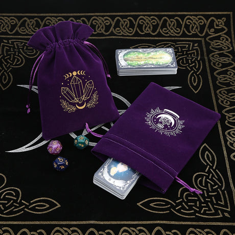 Purple velvet bags with crystal design on a black and gold patterned surface