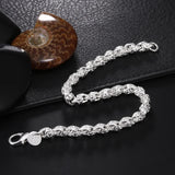 Silver chain bracelet on a dark textured surface