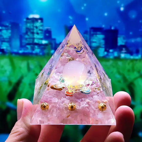 Crystal pyramid with decorative elements held by a hand against a blurred cityscape background