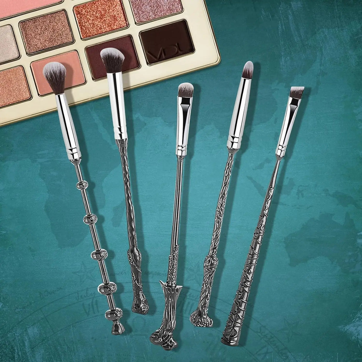 Set of decorative makeup brushes with intricate handles on a teal background