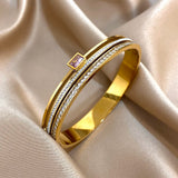Gold ring with a pink gemstone on a beige fabric background