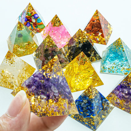 Colorful pyramid-shaped crystals with gold glitter on a white background