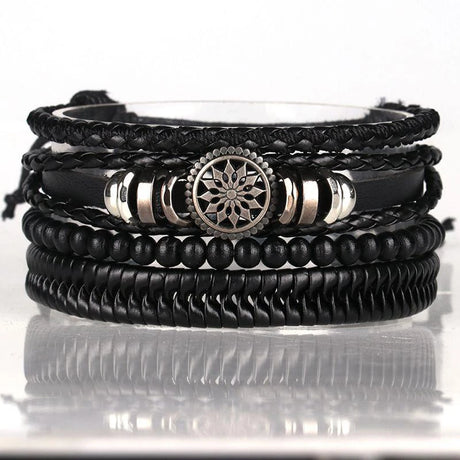 Stack of black leather and beaded bracelets with metal accents on a reflective surface.