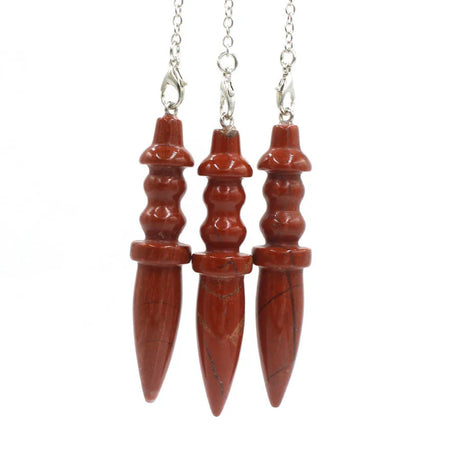 Three red stone pendants on silver chains against a white background