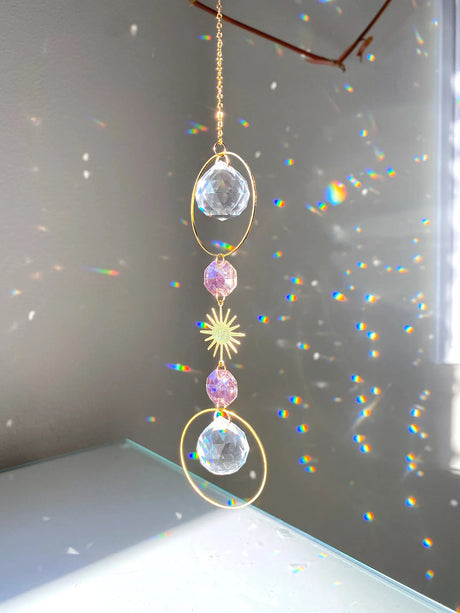 Crystal hanging ornament with rainbow on a neutral background
