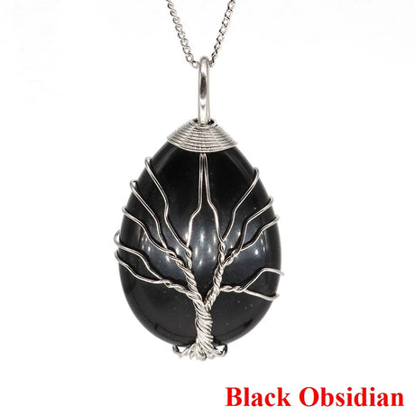 Black obsidian pendant with silver tree design on a white background
