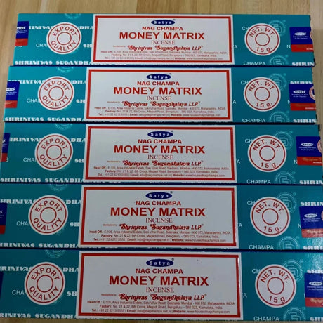Multiple boxes of Satya Nag Champa Money Matrix incense on a wooden surface