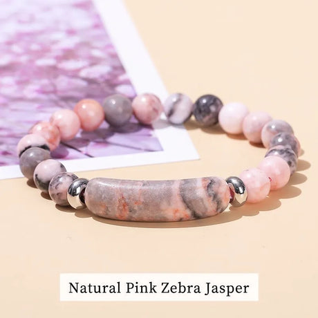 Beaded bracelet with pink and gray zebra Jasper stones on a beige background