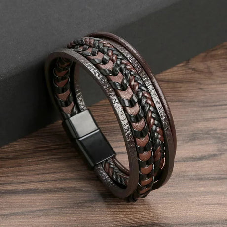 Brown braided leather bracelet with a magnetic clasp on a wooden surface