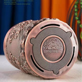 Decorative metal lighter with intricate designs on a white surface