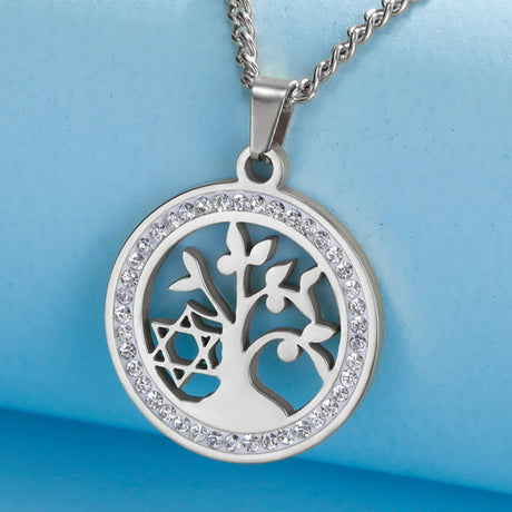 Silver tree of life pendant with clear stones on a blue background