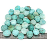 Turquoise stones on a ruler for size reference