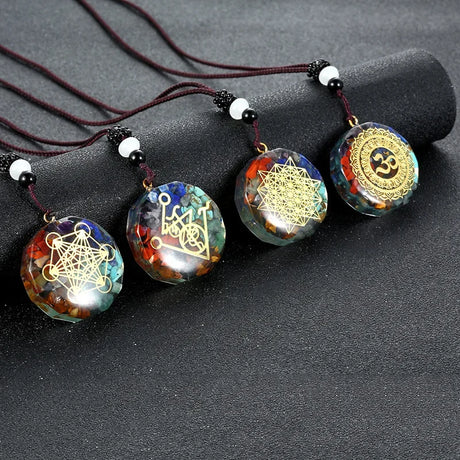 Four decorative necklaces with geometric designs on a black surface