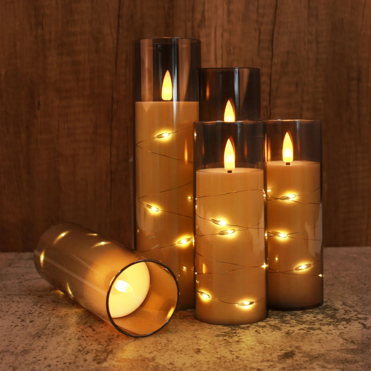 Set of decorative candles with LED lights on a wooden surface