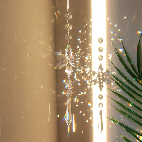 Crystal snowflake ornament with sunlight and plant shadow on a beige wall
