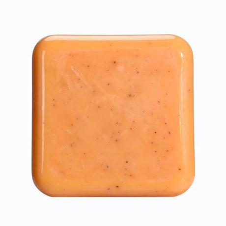 Square bar of orange soap on a white background