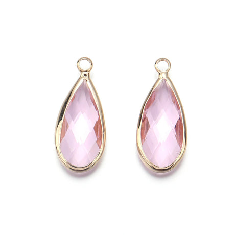 Two pink teardrop-shaped earrings with gold frames on a white background