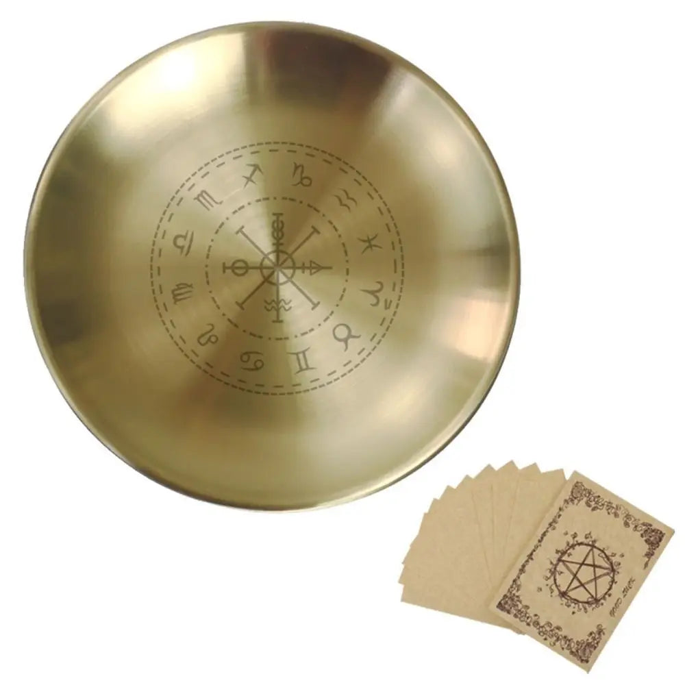 Gold dish with engraved symbols and a set of matching cards on a white background