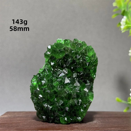 Green crystal rock on a wooden surface with a gray background
