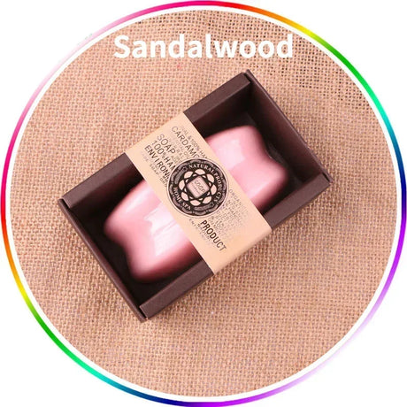 Two pink sandalwood soaps in a brown box on a beige fabric background with 'Sandalwood' text.
