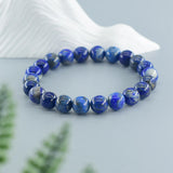 Blue beaded bracelet on a white shell with a light blue background