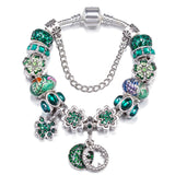 Bracelet with green floral beads and charms on a white background