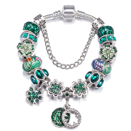 Bracelet with green floral beads and charms on a white background