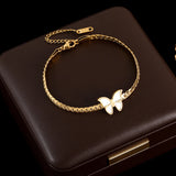 Gold bracelet with a butterfly charm on a dark brown box