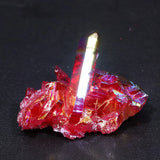 Red crystal with a clear, reflective point on a dark background