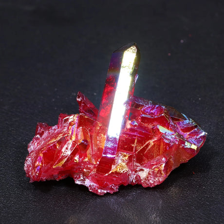 Red crystal with a clear, reflective point on a dark background