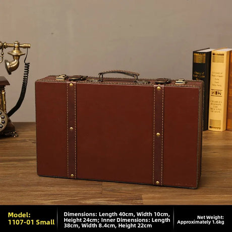 Vintage-style brown suitcase on a wooden surface with books and a phone in the background.