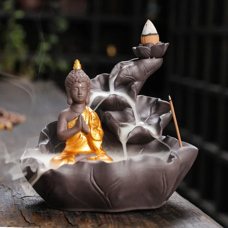 Decorative incense burner shaped like a Buddha figure with smoke rising.