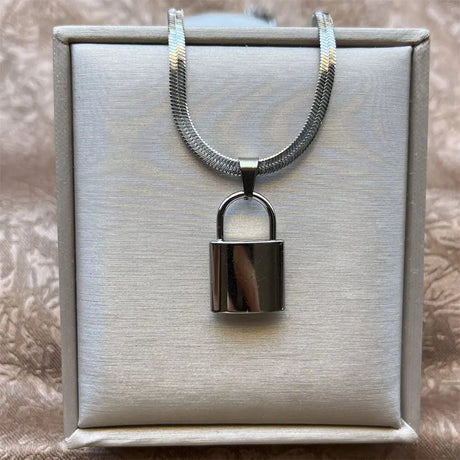 Silver padlock necklace on a gray box