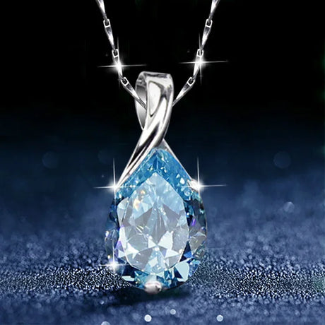 Silver necklace with a blue teardrop pendant on a dark background