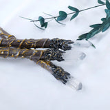 Decorative staffs with crystal tips on a white background with green leaves.