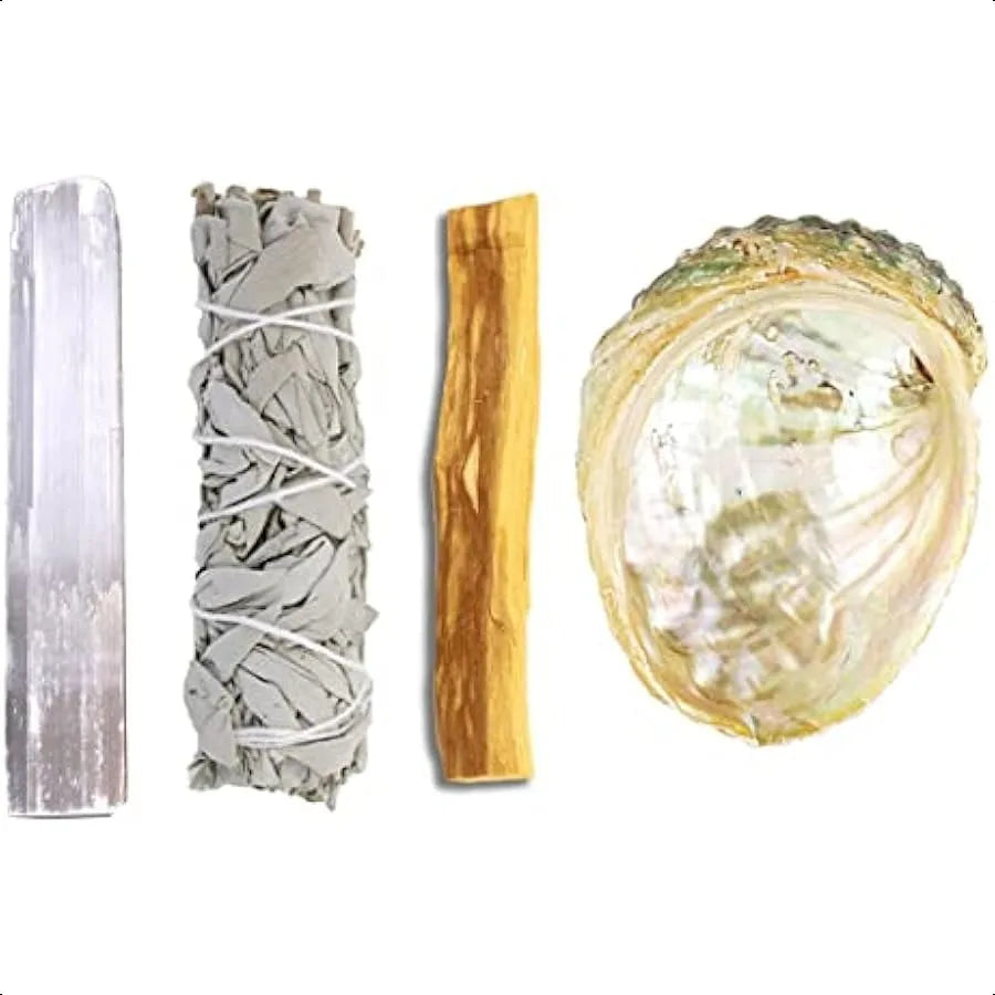 Set of four items including a crystal, sage, and two wooden sticks on a white background