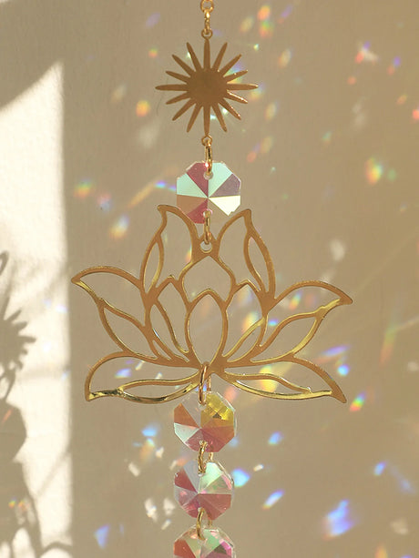 Decorative gold lotus flower with colorful crystals against a neutral background