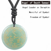 Green pendant with gold symbols on a black cord against a white background