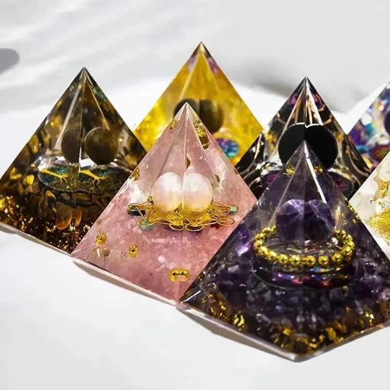 Pyramid-shaped crystal objects with embedded stones on a white background